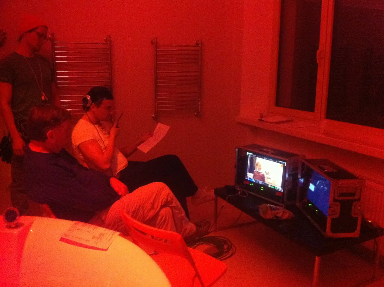 A crew at a monitor under red light